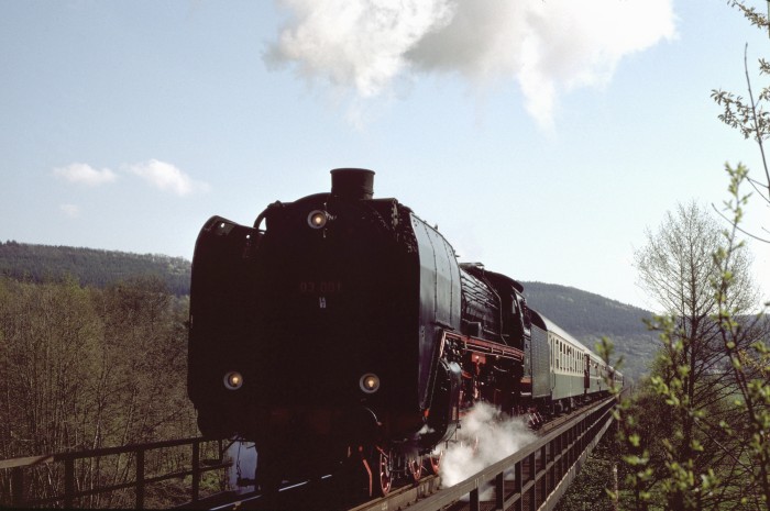 03 001 mit BVG-Sonderzug auf der Gitterbrücke, die vor der Einfahrt von Gamburg über den Fluß Tauber und die Landstraße führt, am 20.04.1997