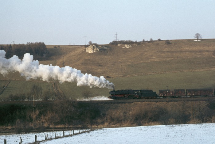 044 195 Tv schiebt hier einen von der 050 737 gezogenen Güterzug aus Northeim nach Ellrich die bekannte Osterhagener Rampe bei Bartolfelde hoch, 17:15h am 19.03.1976