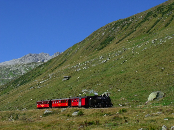 BFD 9 kommt mit dem Zug Oberwald →Realp abwärts fahrend zwischen Sidelenbach und Steinstafelviadukt im oberen Furkareusstal, um 12:12h am 29.08.2015
