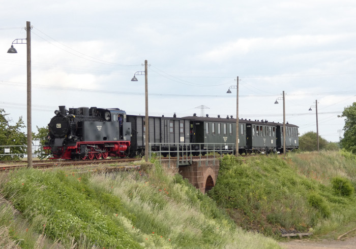 Lok 11  mit Regelzug →Benndorf auf der Schmalspur-Überführungsbrücke an der Einfahrt am Hp (ohne Halt) und ehem. Abzweig Bocksthal, um 16:15h am 26.05.2022