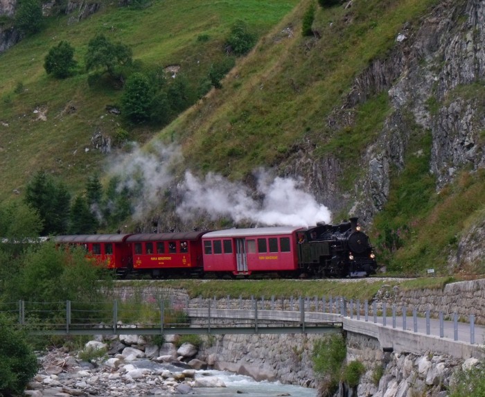 FO 4 mit Zug von Gletsch nach Realp im Reusstal wenige hundert Meter vorm Betriebswerk der Bahn vor Realp, um 16:51h am 23.08.2014