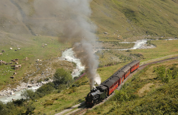 Lok 704 mit Zug Nr.133 Realp&rarr;Oberwald, aufgenommen und fotografiert im Furkareusstal hinter dem Hp Tiefenbach kurz hinter dem Beginn der Zahnstange, um 10:46h am 14.08.2026
