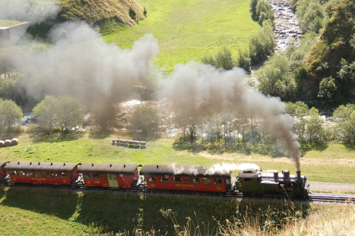 Lok 704 mit Zug 133 Realp&rarr;Oberwald im Furkareusstal schon in der Bergfahrt etwa hundert Meter nach Beginn der Zahnstange, um 10:27 am 15.08.2026